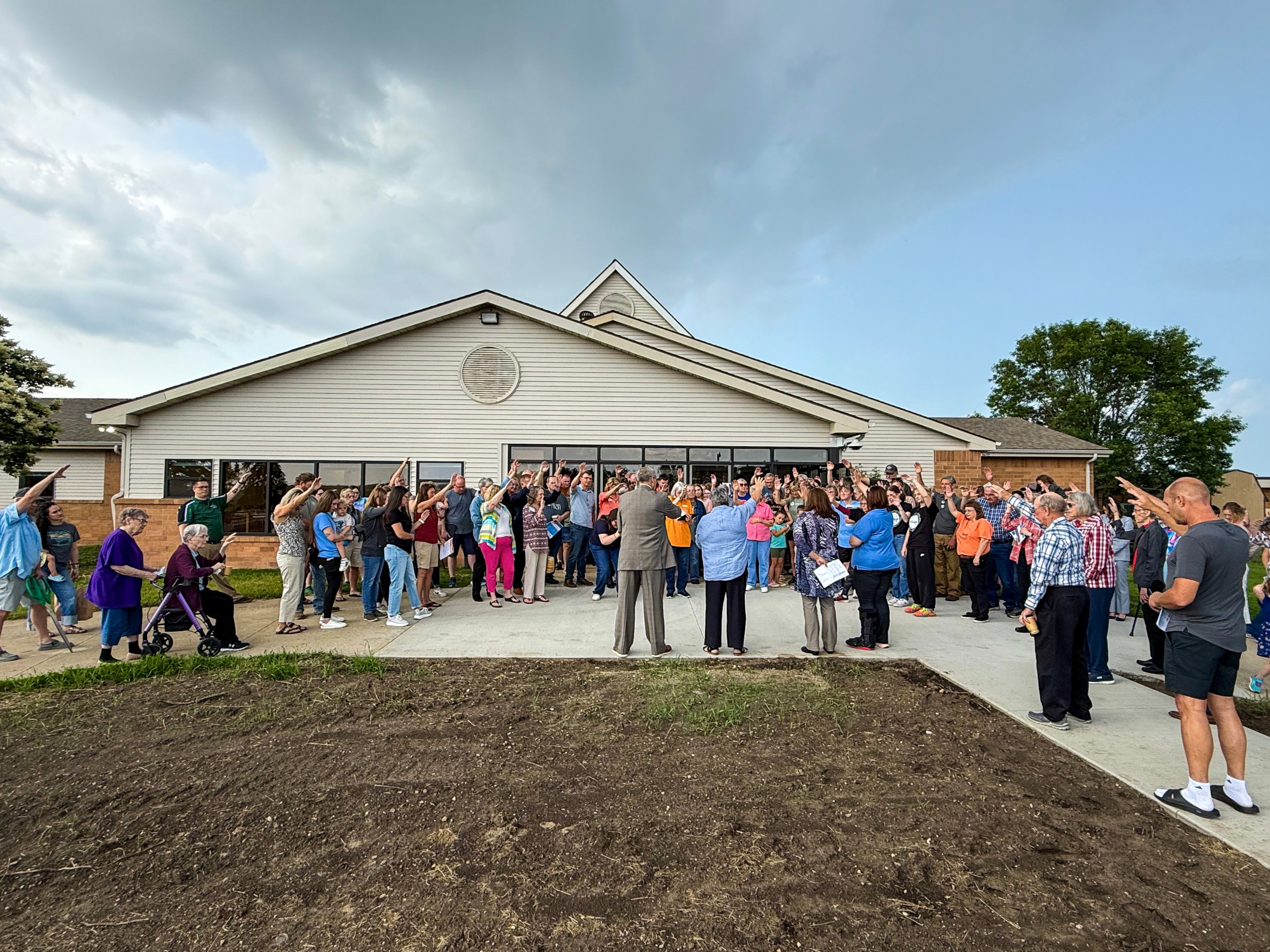 At the grand opening ribbon cutting, Sister Barb led the crowd in prayer–hands raised to the heavens as a blessing over Our Little Village Learning Center.